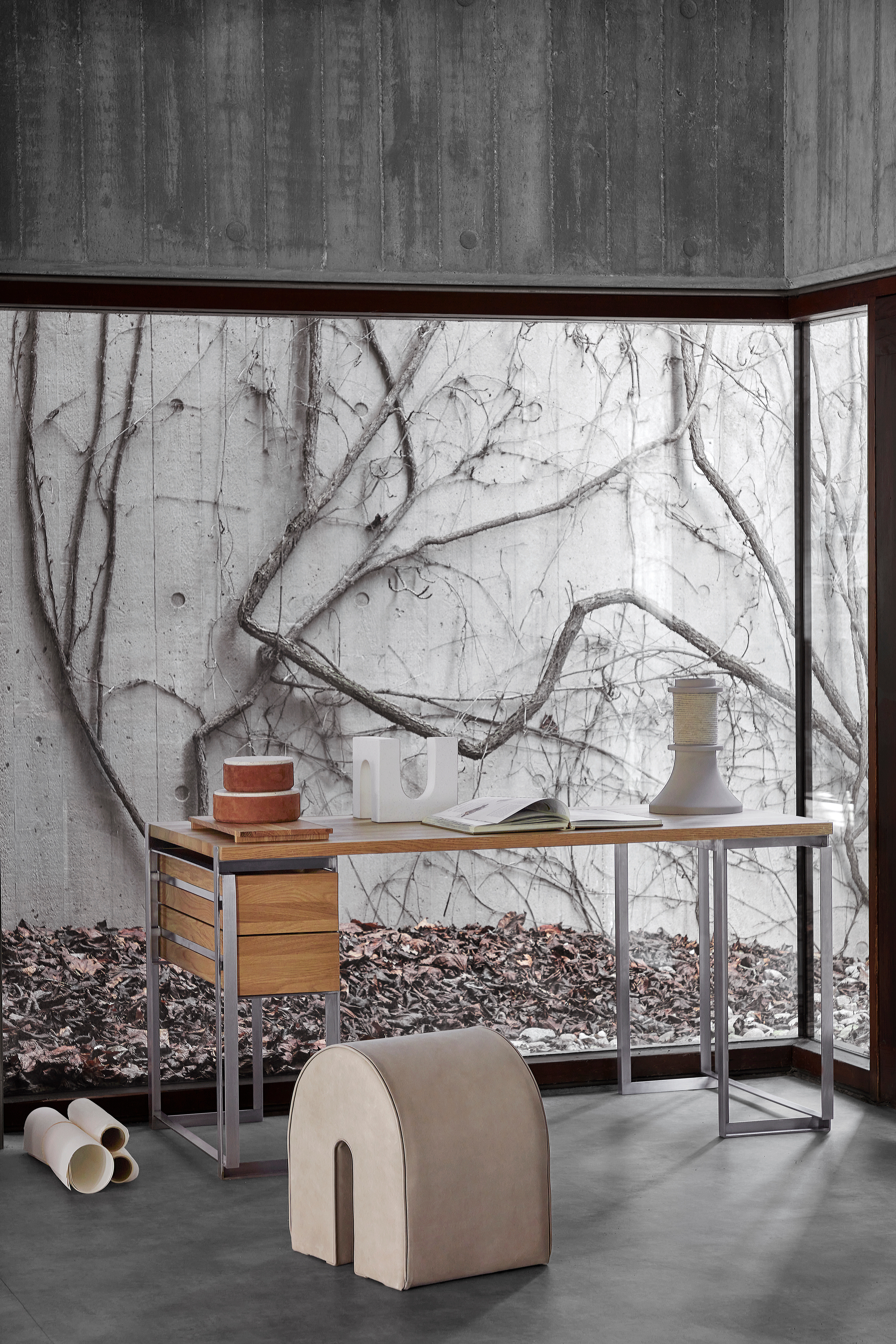 Reduzierter Arbeitsplatz vor Fensterfront mit Rankenblick, Schreibtisch und Skulptur davor