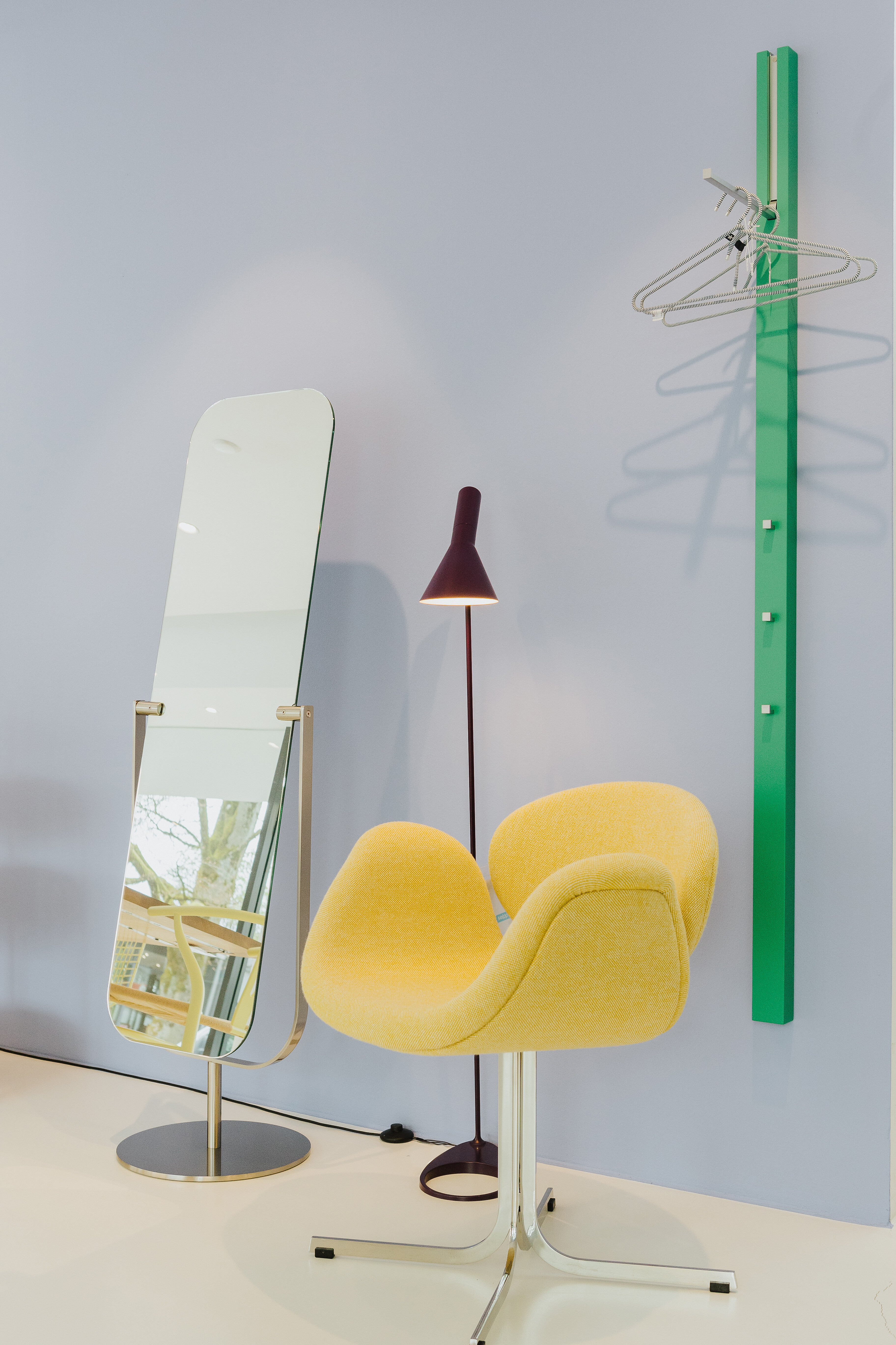 Garderobe Line von Schönbuch in kräftigem Grün, kombiniert mit gelbem Stuhl und Standspiegel