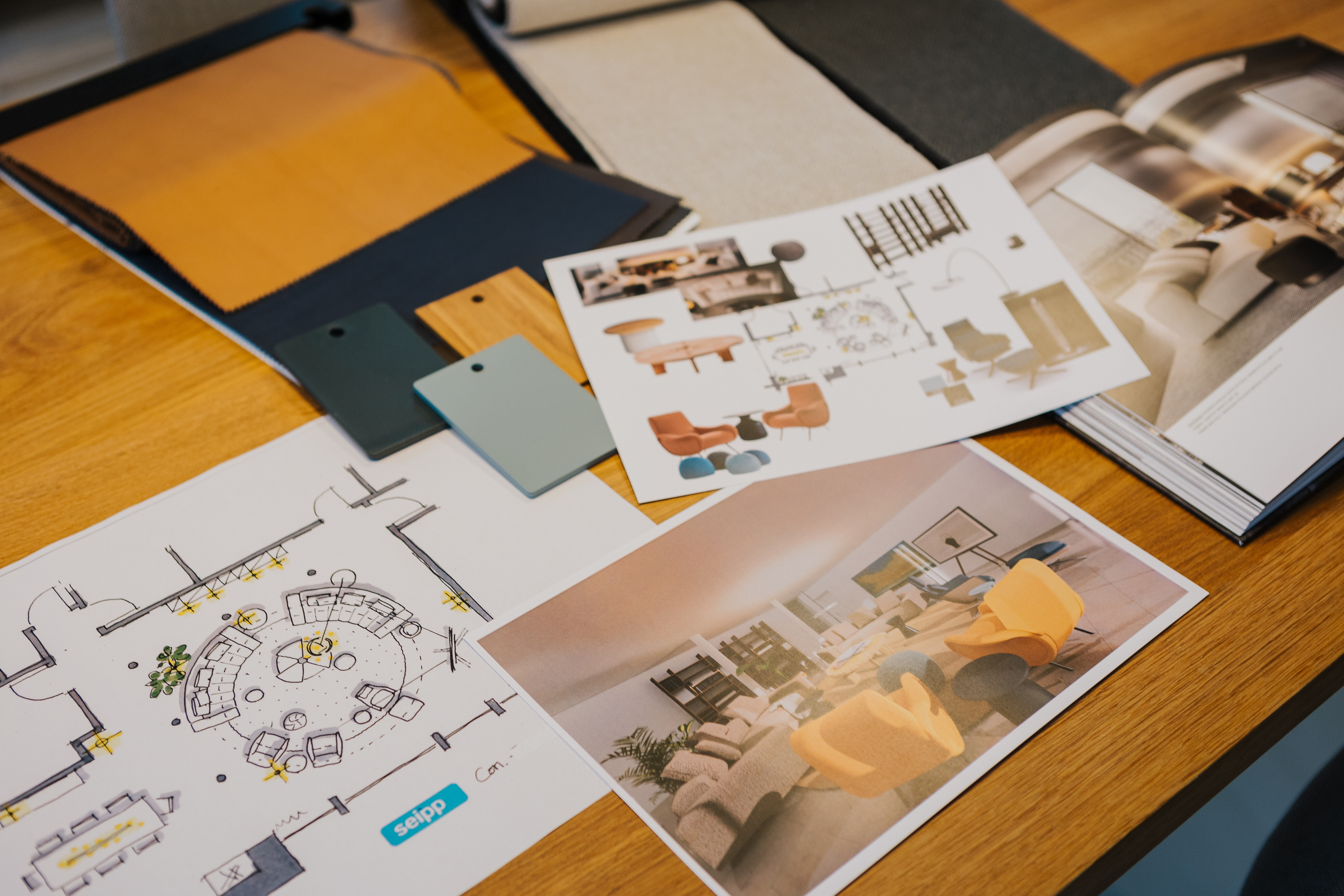 Planungsunterlagen mit Moodboard, Materialmustern und Grundriss auf einem Holztisch arrangiert