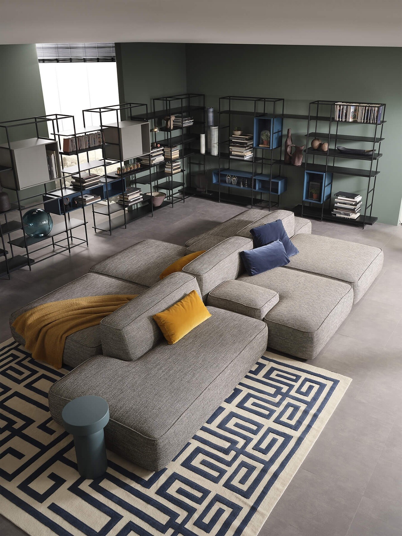 Großzügige Sofalandschaft mit Teppich und offenen Regalen in einem wohnlichen Raum