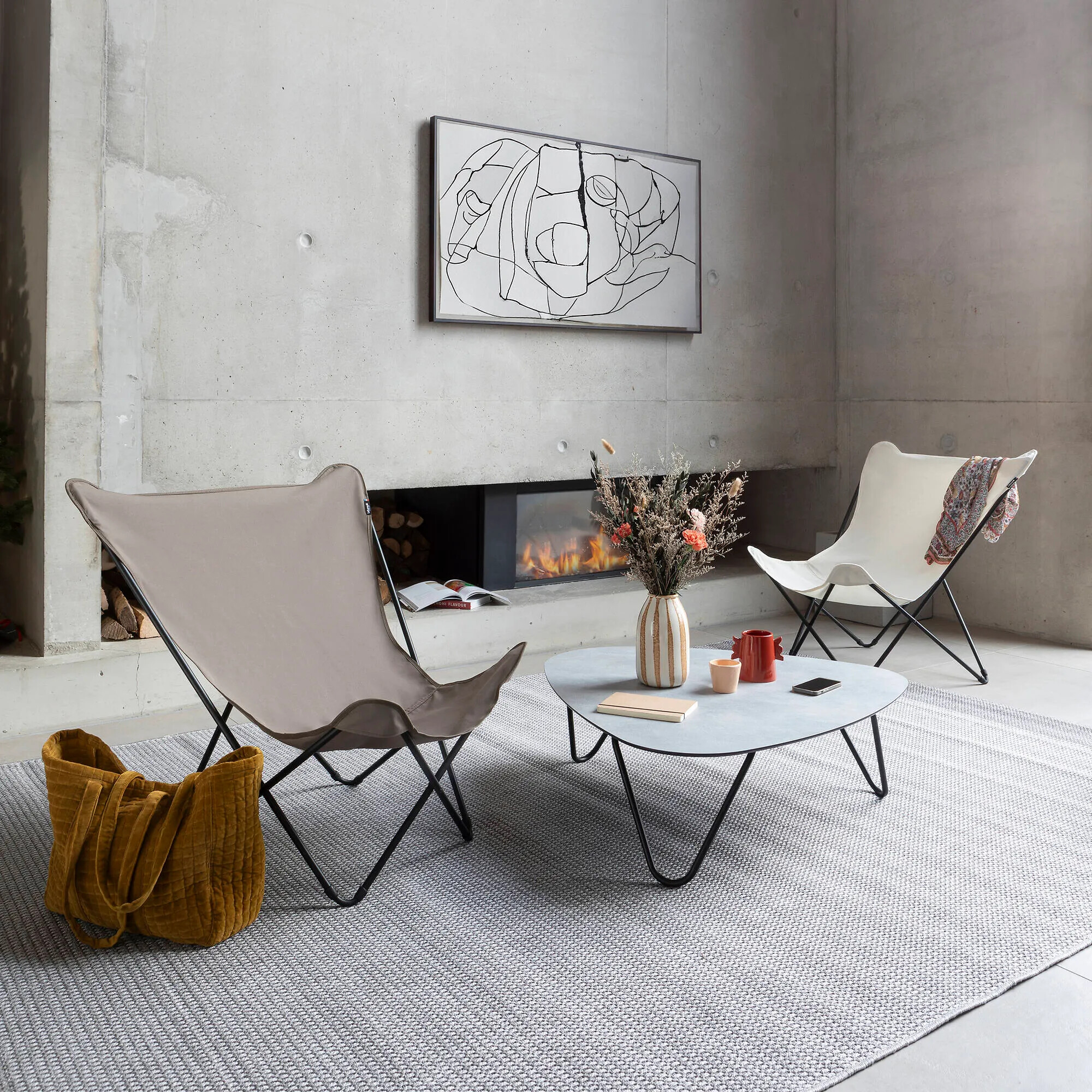 Zwei Butterfly Chairs von Lafuma mit Stoffbespannung vor Kamin und Couchtisch