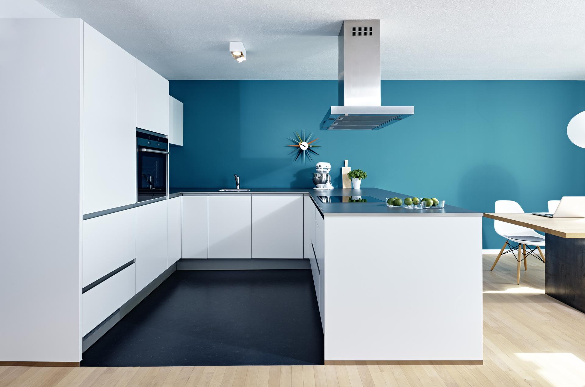 Die Küche in Softlack weiß mit Griffleisten und Schichtstoffarbeitsplatte mit Edelstahlkante überzeugt durch ihre Schlichtheit.