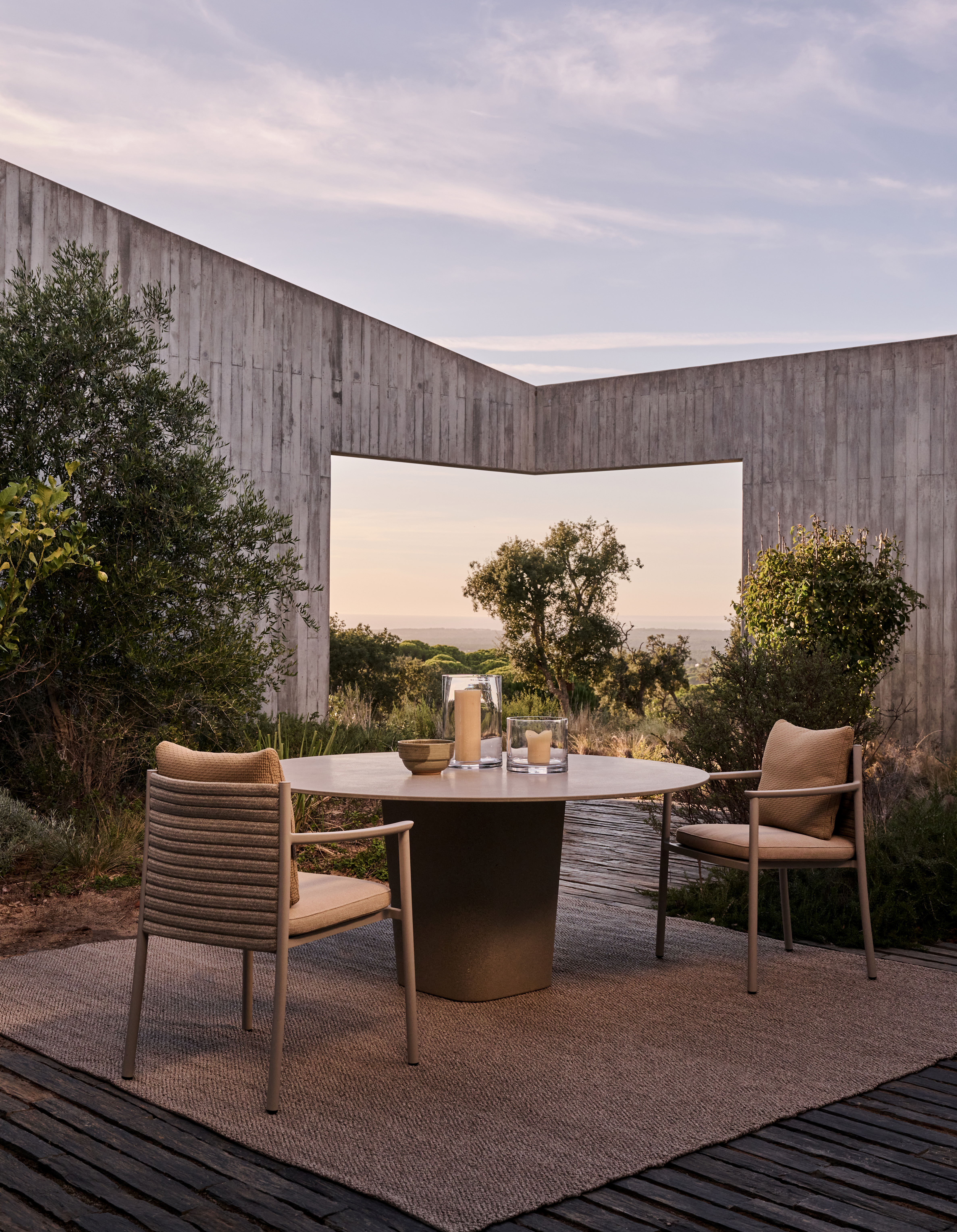 Tribu Outdoor-Set Lucca mit rundem Tisch in stimmungsvoller Umgebung bei Abendlicht