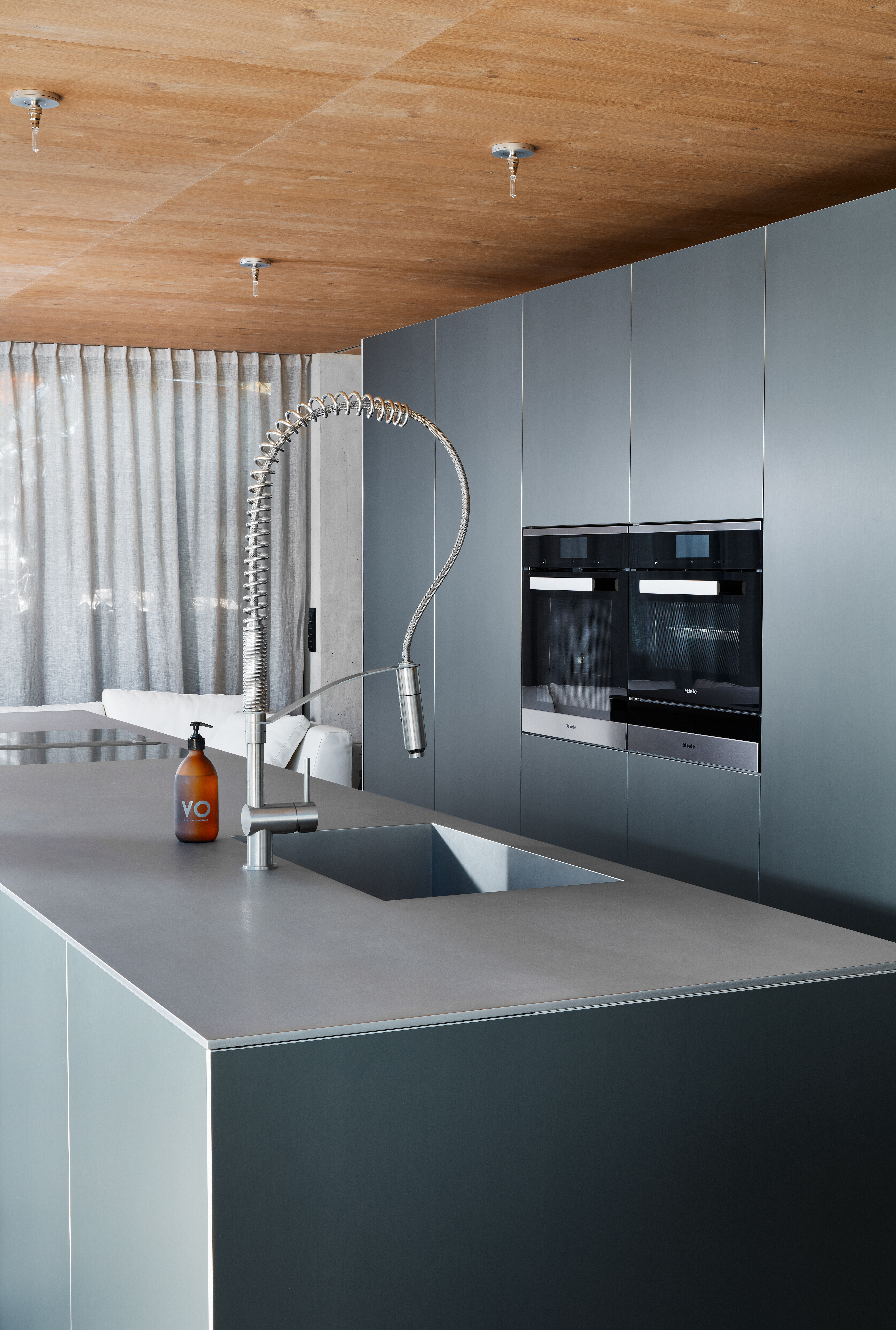 Beton, Holz und Glas bilden die Basis des modernen Neubaus. Mittelpunkt ist das offen gestaltete Erdgeschoss mit Wohn-, Koch- und Essbereich. Eine Besonderheit ist bereits von außen gut ersichtlich – das verbindende Element Eichenholz. Im Erdgeschoss zier