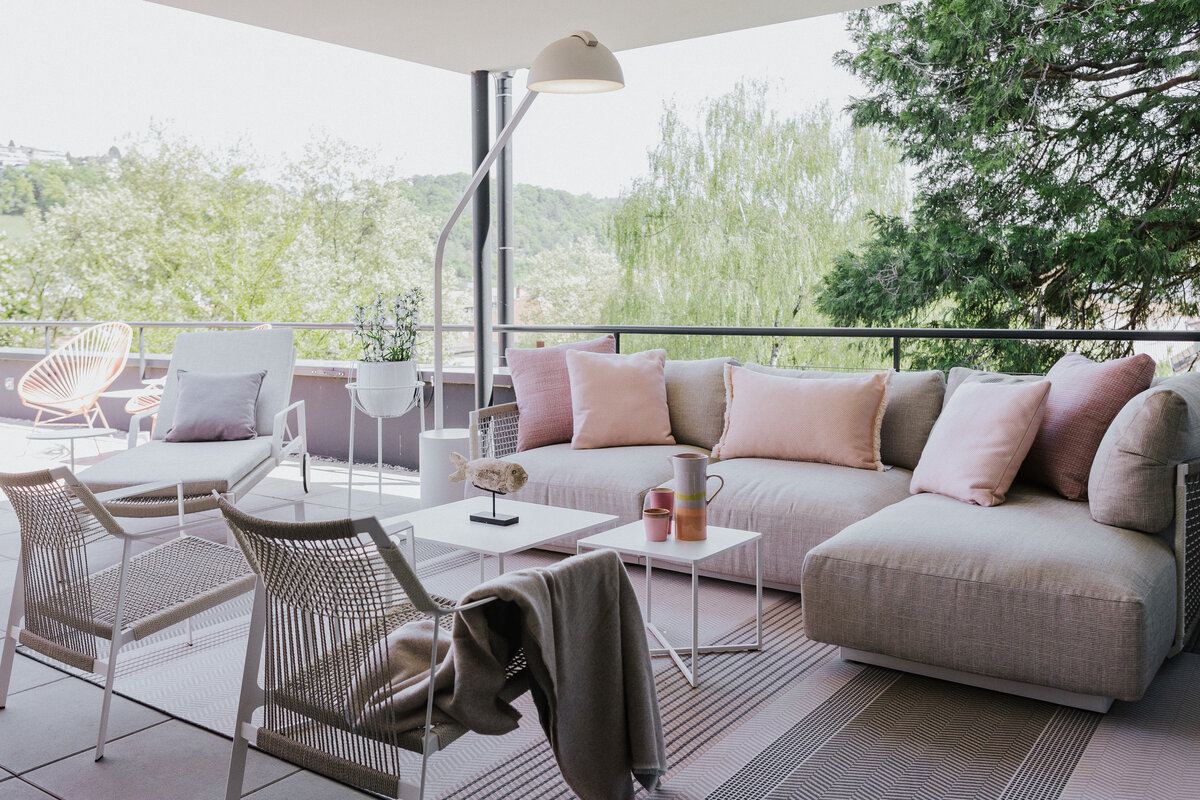 Gartenmöbel auf der Dachterrasse Tiengen mit Lounge-Sofa in Beige und roséfarbenen Akzenten