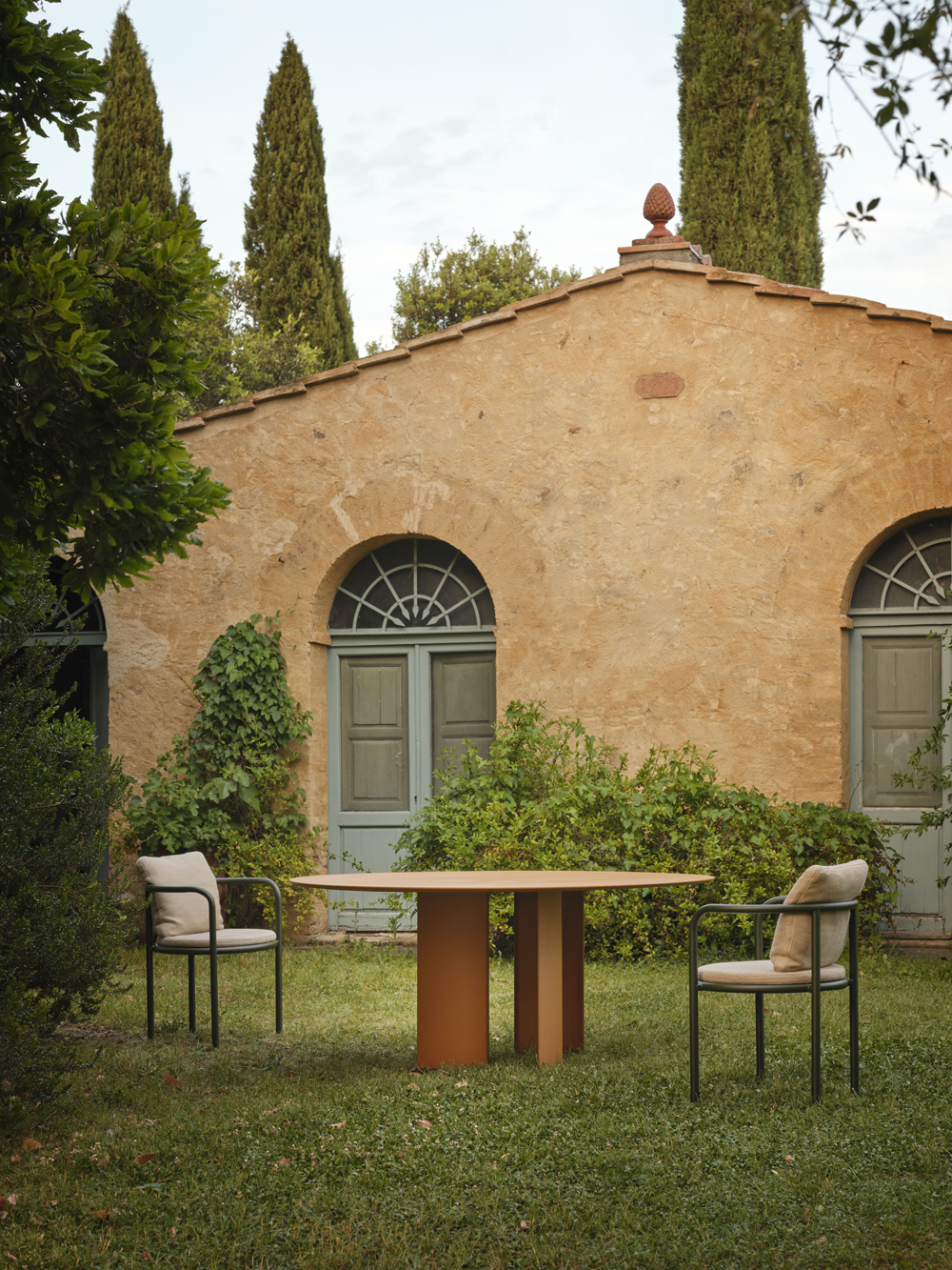 Runder Esstisch Naca von Fast mit zwei gepolsterten Stühlen im Garten vor historischem Gebäude