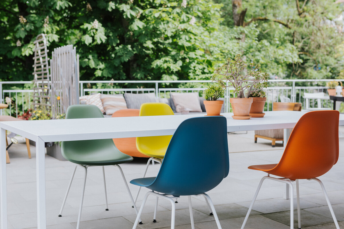 Eames Plastic Side Chairs in verschiedenen Farben auf der Terrasse der Ausstellung Seipp Wohnen Waldshut
