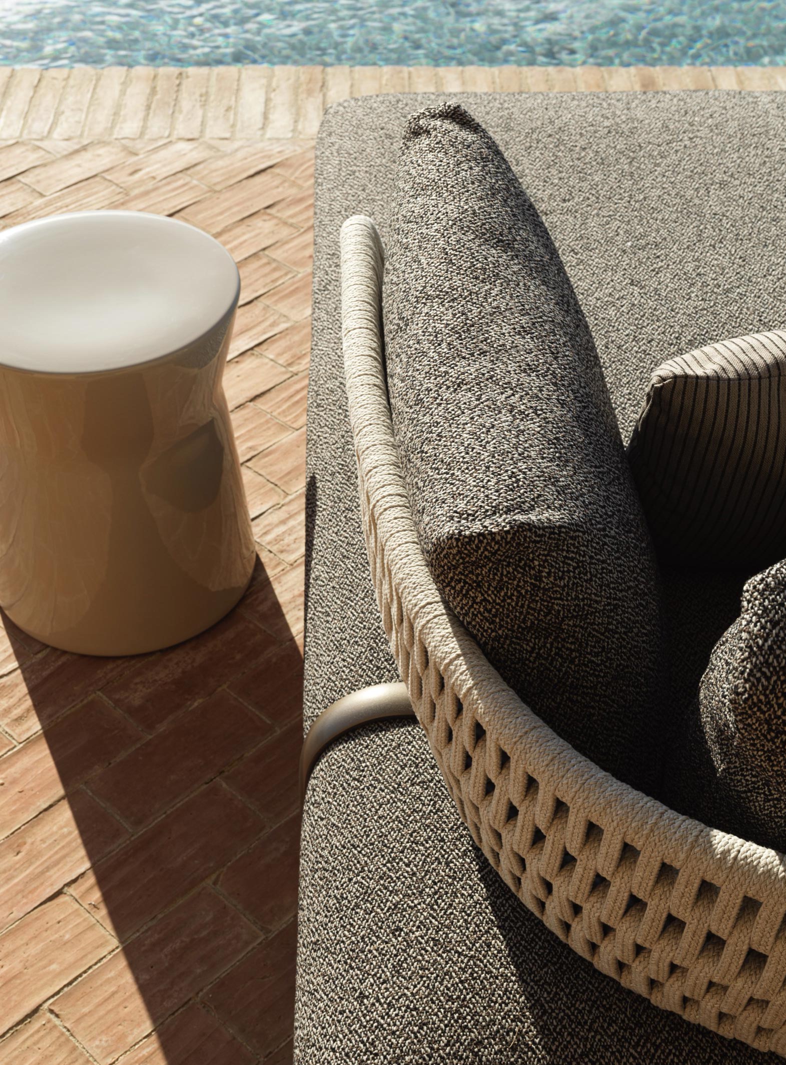 Detailansicht des Molteni&C Sofa Sway mit textiler Polsterung und geflochtener Rückenlehne am Pool