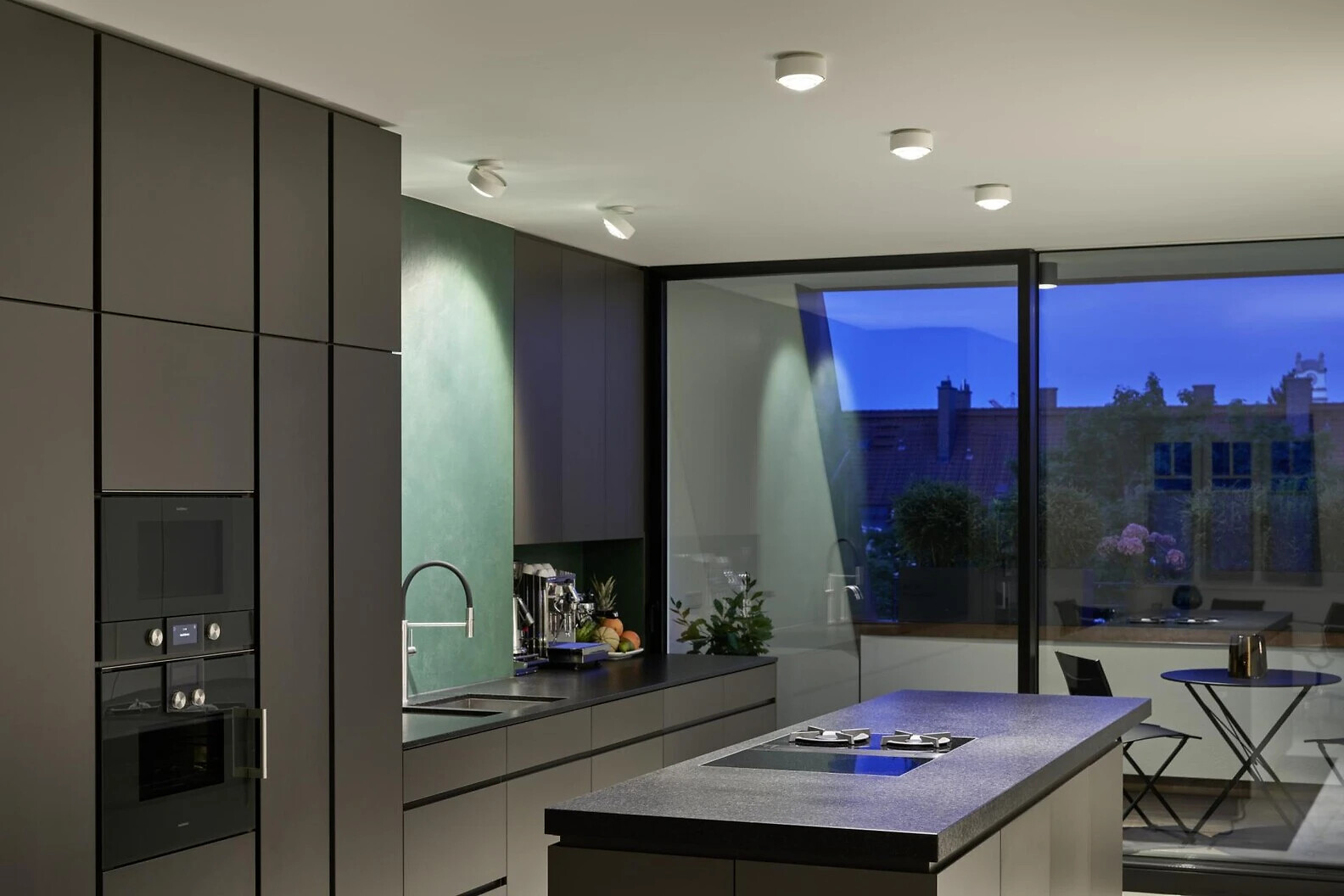 Helle Küche mit Inselblock und mehreren Più alto Deckenleuchten von Occhio im Innenbereich