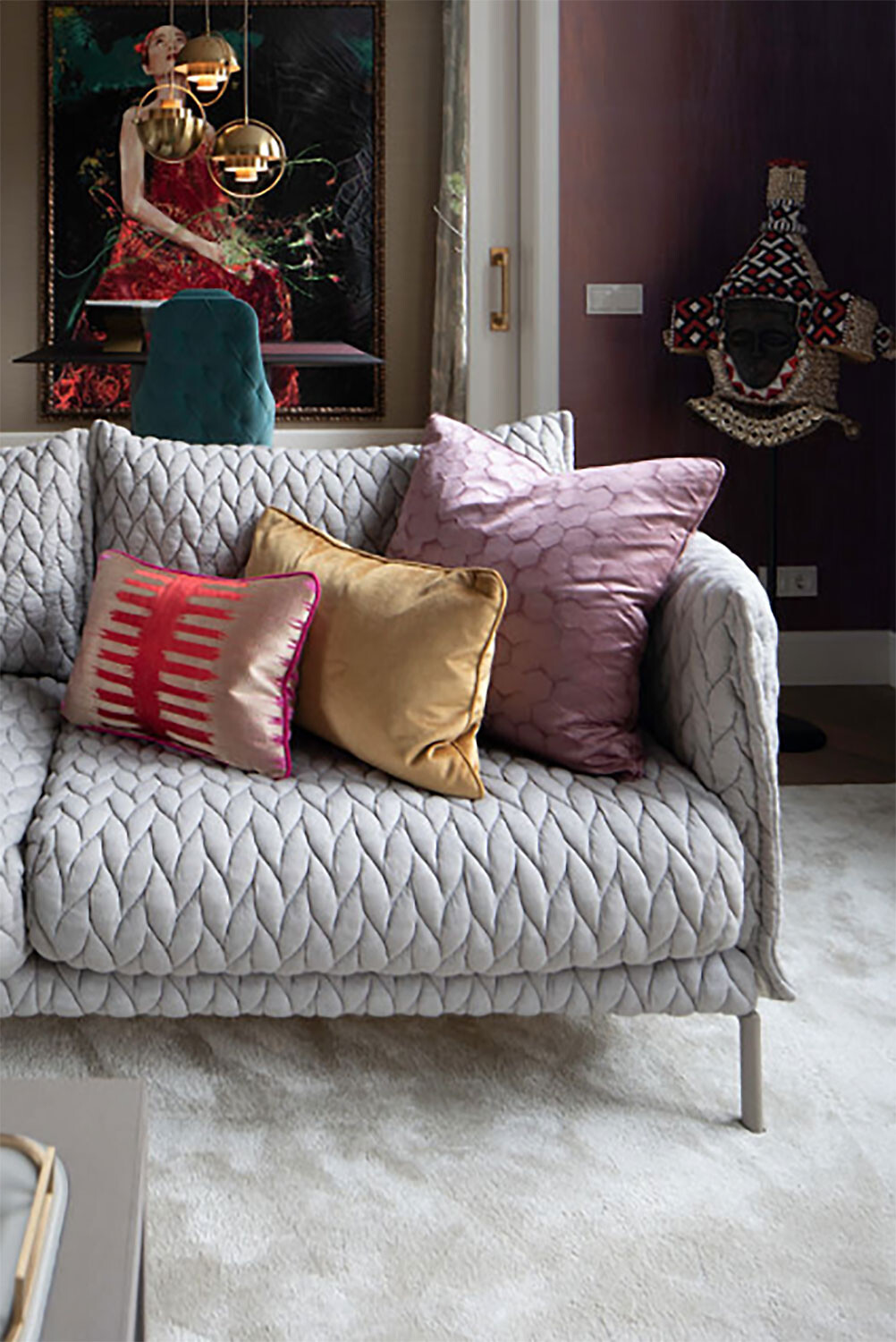 Gepolstertes 2-Sitzer-Sofa mit strukturierter Oberfläche und Kissen in verschiedenen Farben