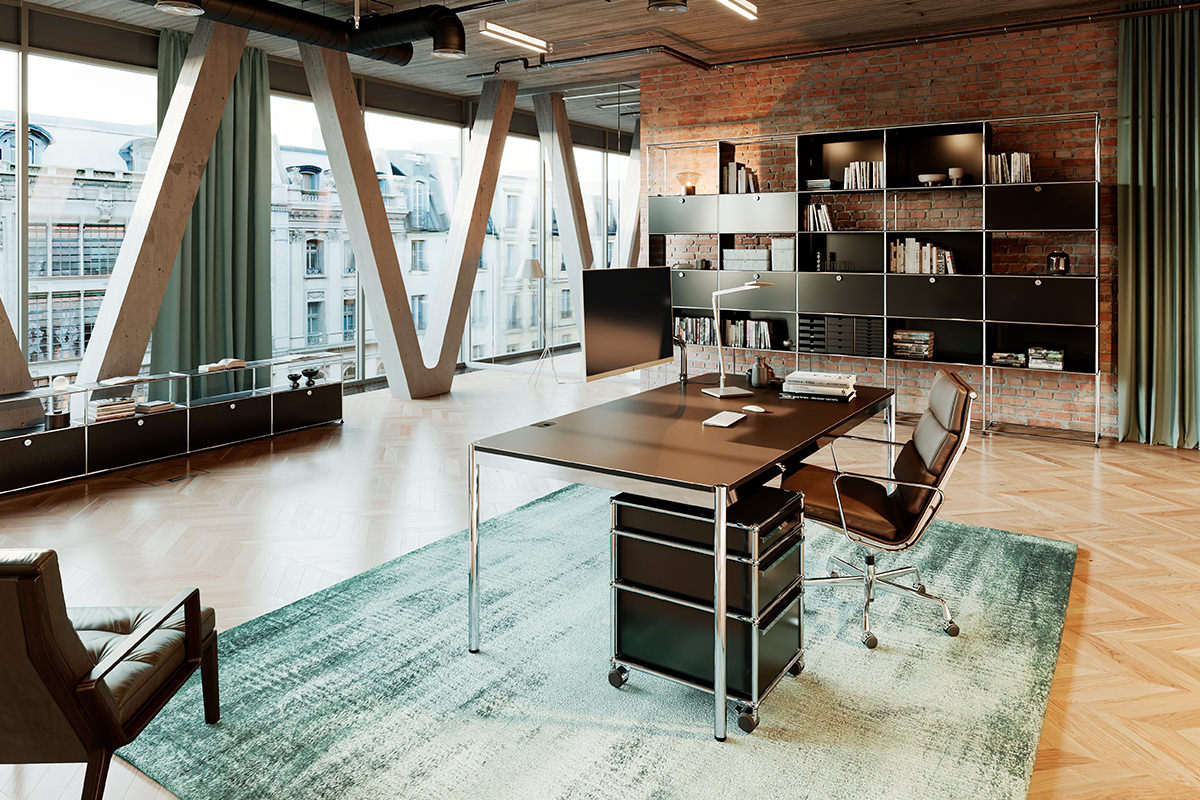 Das moderne Loft-Büro zeigt USM Haller Möbel. Ein USM Schreibtisch mit Rollcontainer und passende Regale bieten Funktionalität. Der Vitra Aluminium Chair rundet das professionelle Ambiente stilvoll ab.