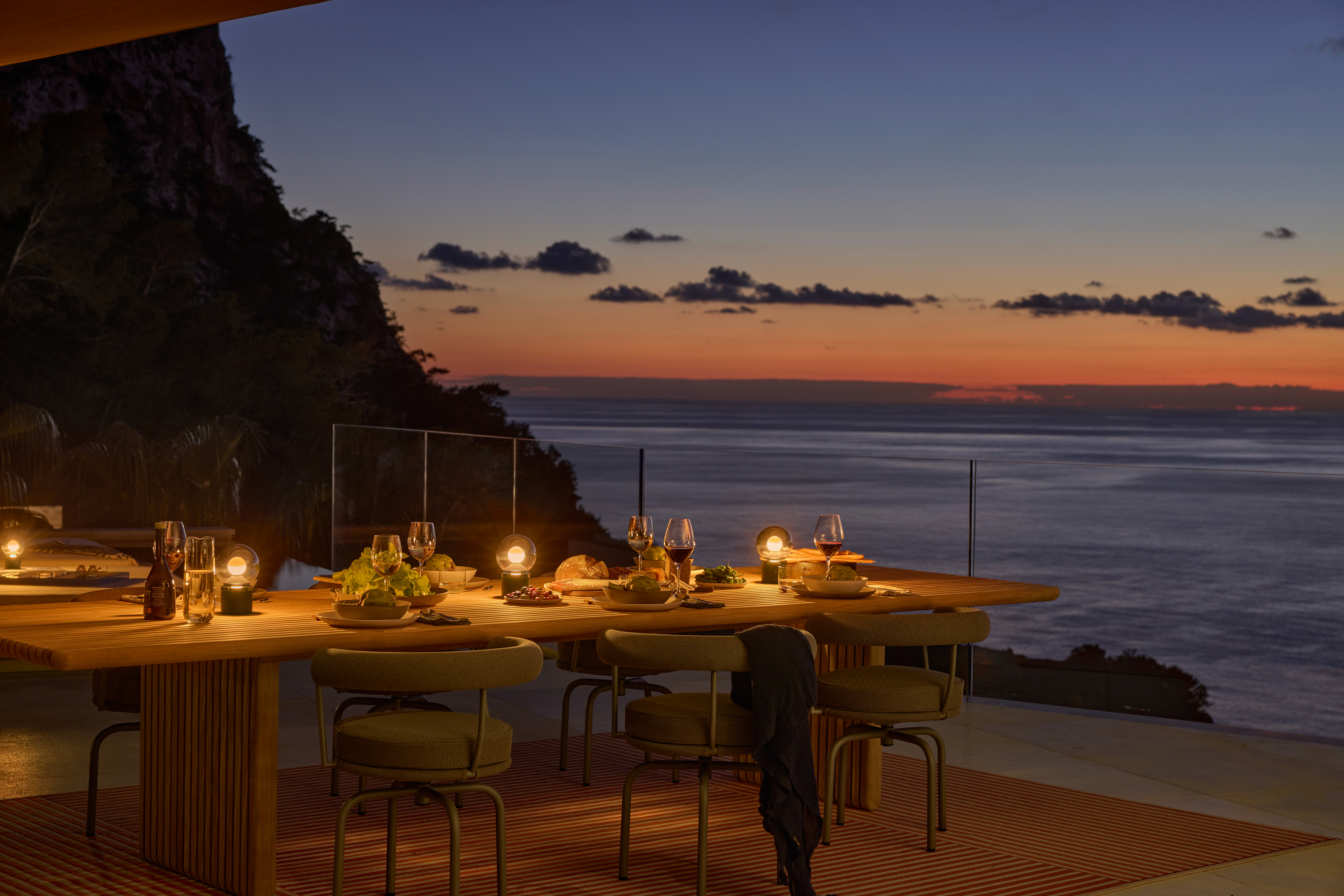 Luna pura Leuchten auf einem gedeckten Tisch in abendlicher Szenerie mit Meerblick