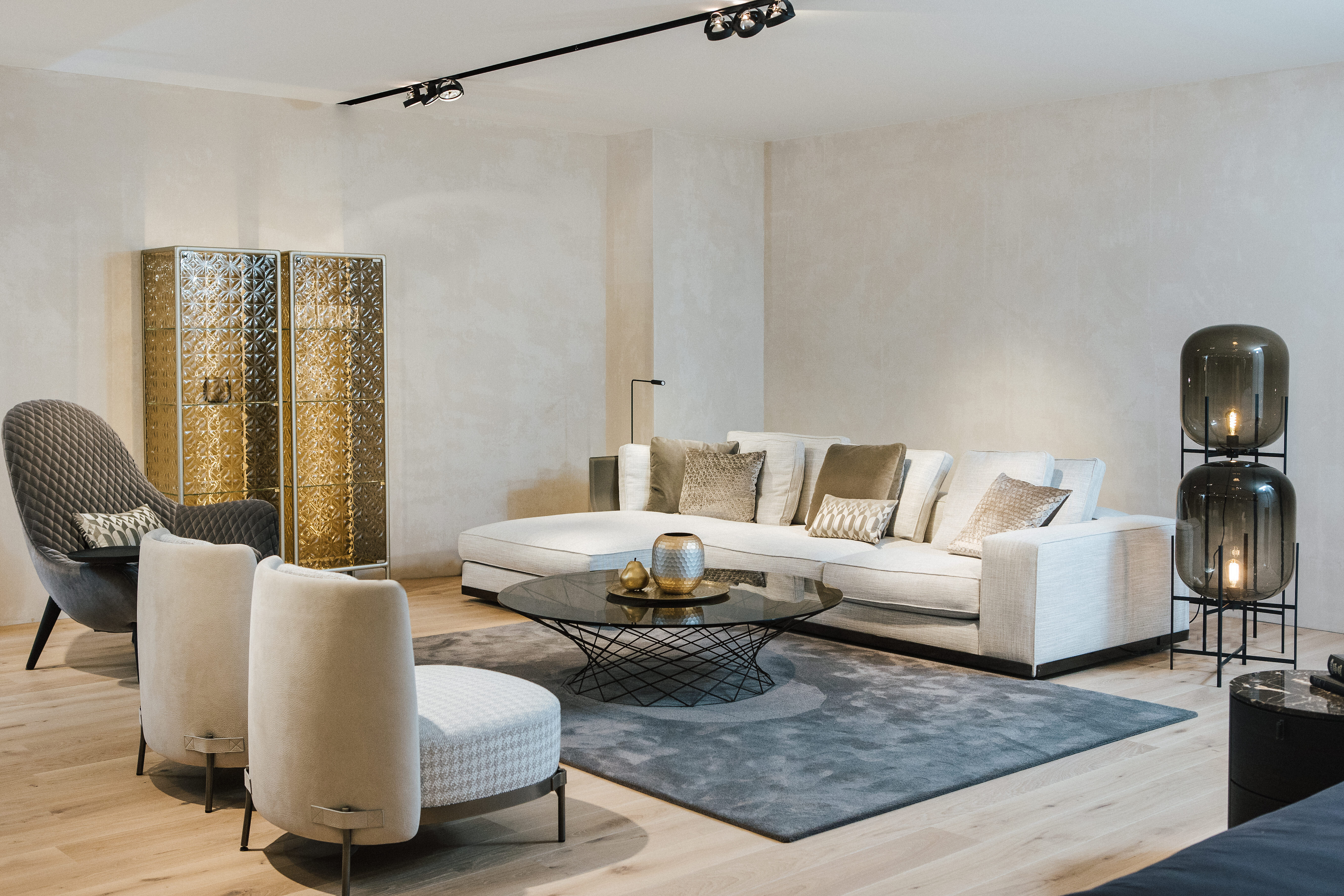 Wohnbereich mit heller Polstergruppe, Pulpo-Leuchten und eleganten Akzenten in Gold und Glas