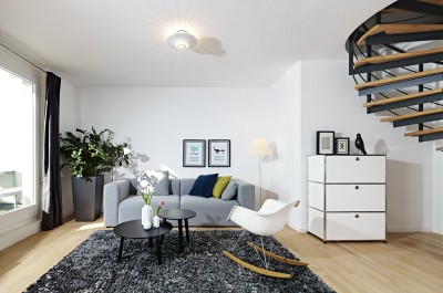 Im offenen Wohnbereich finden Klassiker, wie der Schaukelstuhl RAR von Vitra, das USM Highboard und neue Designstücke wie das Sofa Mags und die Beistelltische Bella Coffeetable von HAY einen schönen Platz.